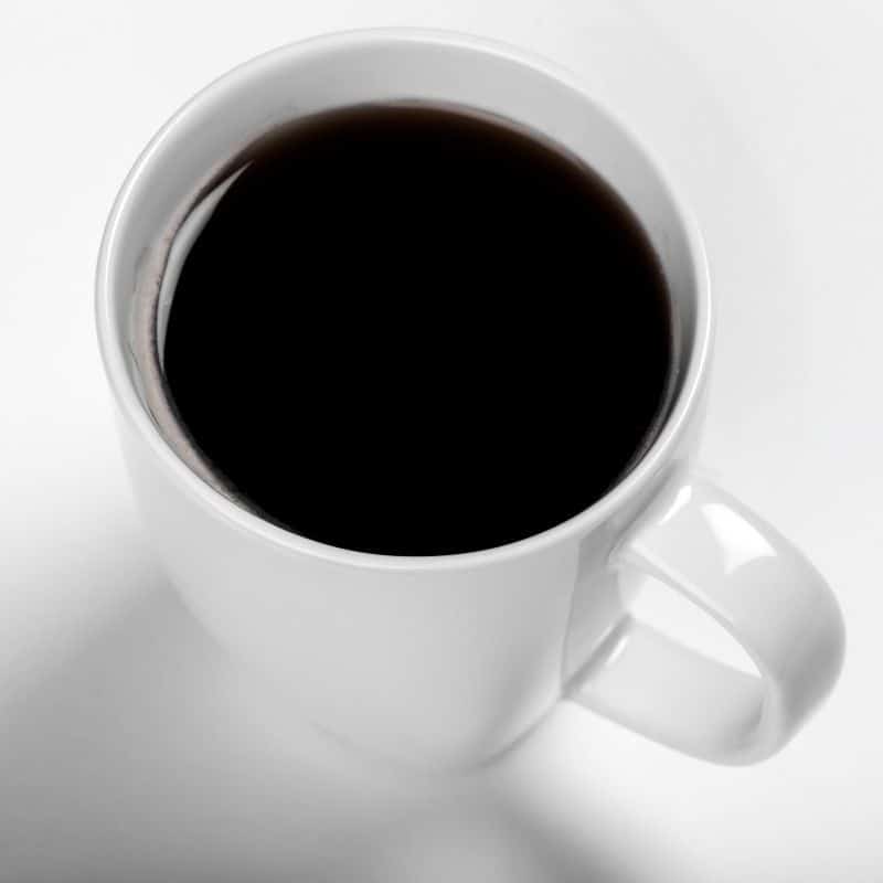 white coffee cup filled with black coffee