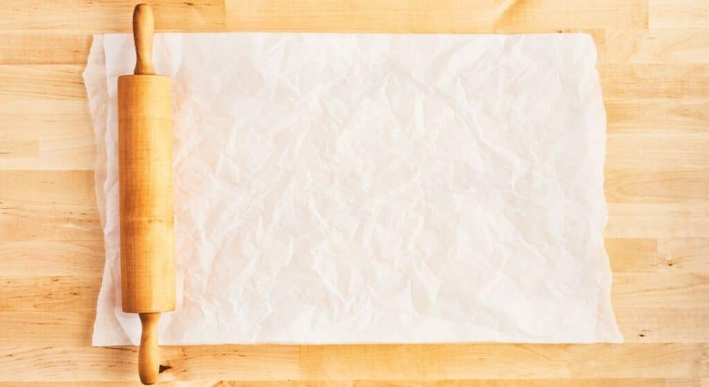 rolling pin and parchment paper on wood counter