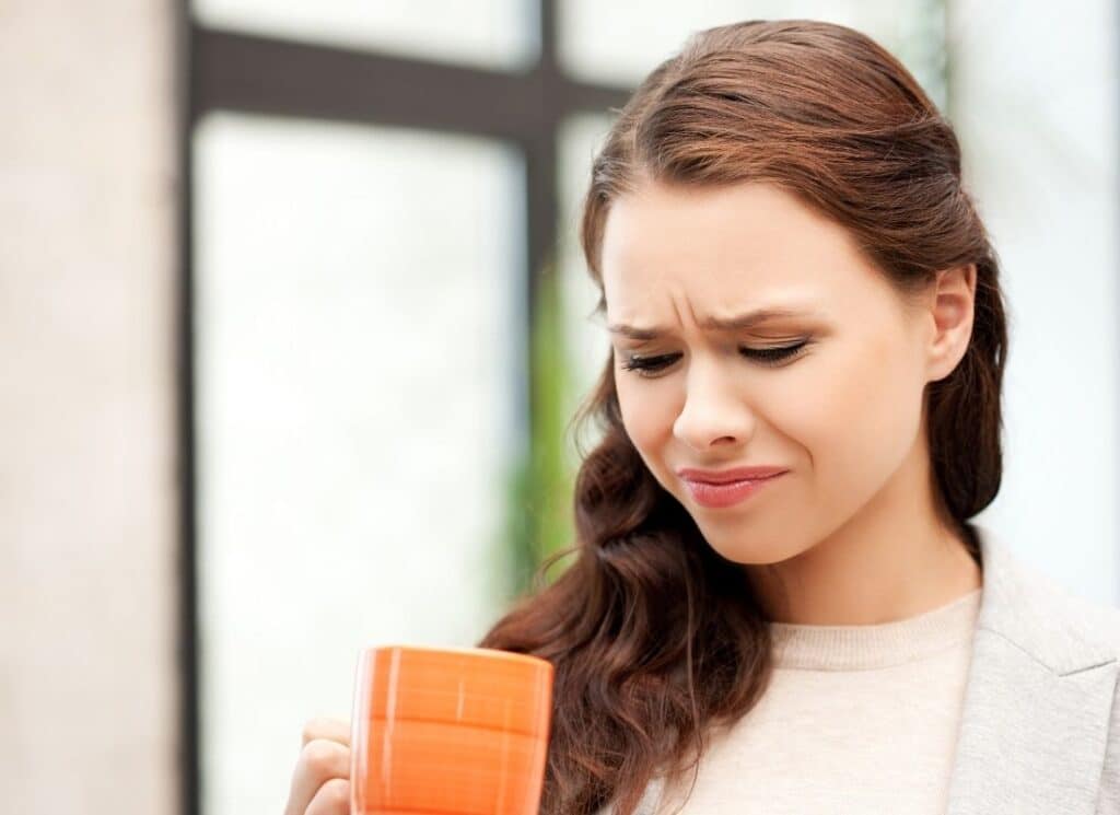 lady looking at a mug in disgust 