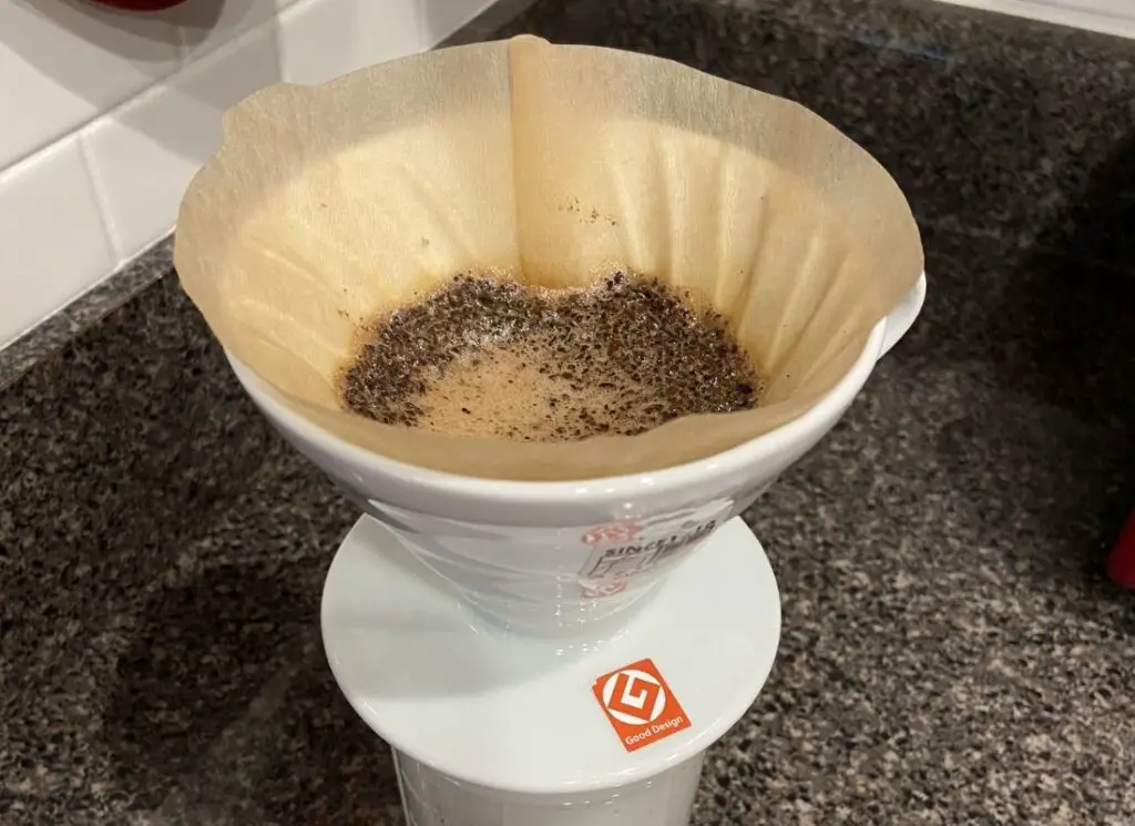 V60 pour over coffee maker with filter and coffee grounds