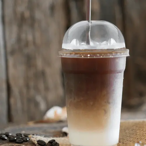 iced caramel macchiato in plastic cup with a straw